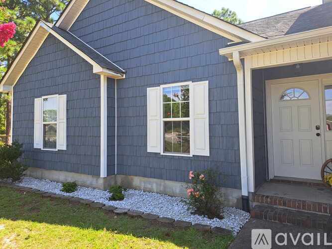A small blue house with a white door and windows.