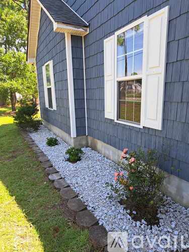 A house with a blue siding and white trim windows.