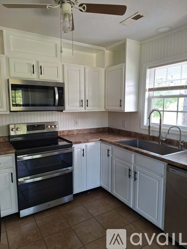 A kitchen with white cabinets and a black stove top oven.