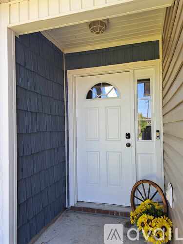 A white door with a window cutout is flanked by a white wall and a blue wall.