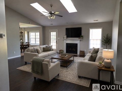 A living room with a fireplace and a television on the wall.