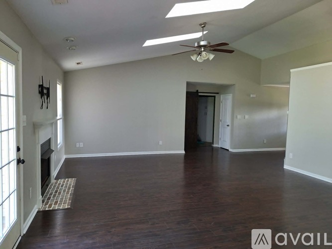 A spacious room with a fireplace and a ceiling fan.