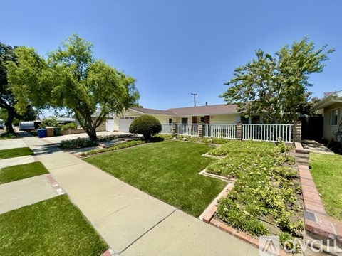 A house with a white picket fence and a well-manicured lawn.
