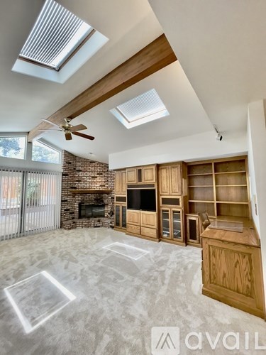 A spacious living room with a fireplace and wooden cabinetry.