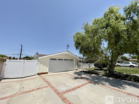 A house with a garage and a tree in front.