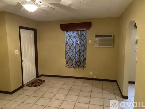 A room with a door, window, and a fan.
