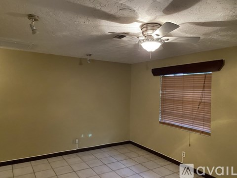A room with a ceiling fan and a window with blinds.