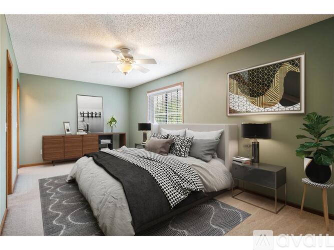A bedroom with a bed, nightstand, and a ceiling fan.