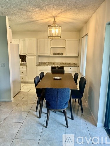 A dining room with a table and chairs.