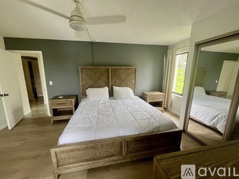 A bedroom with a large bed and a mirror on the wall.