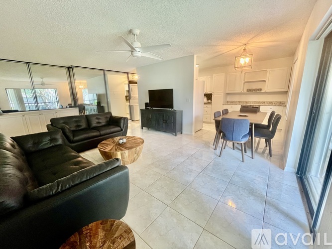 A living room with a black leather couch and a television.
