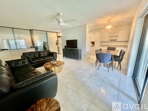 A living room with a black leather couch and a television.