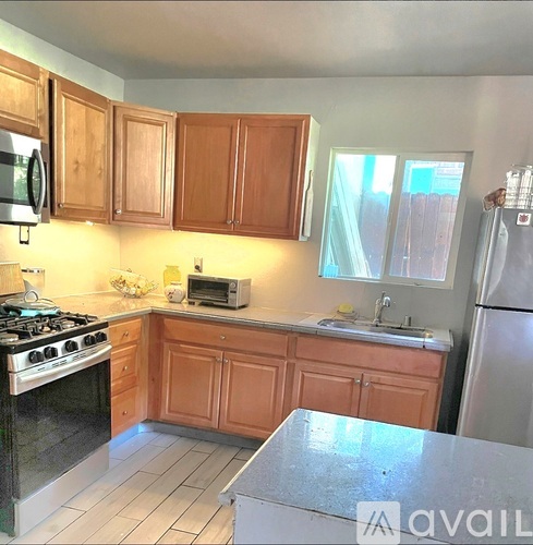 A kitchen with wooden cabinets and a black stove top.
