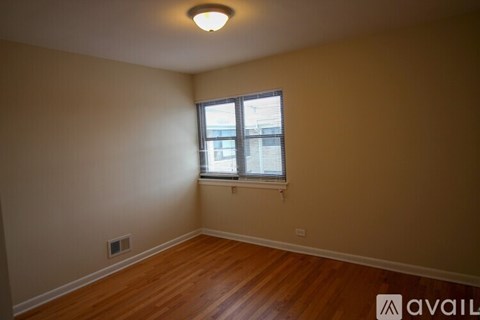 A room with a window and wooden flooring.