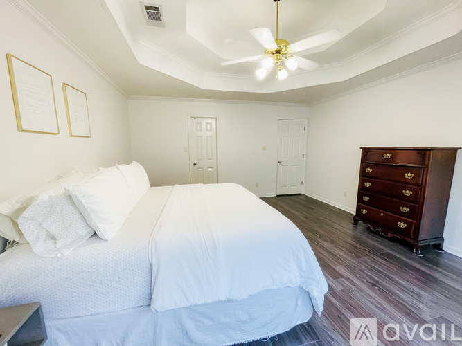 A bedroom with a large bed and a dresser.