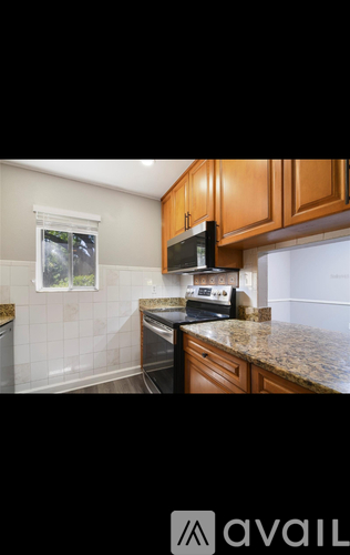 A kitchen with wooden cabinets and a granite countertop.