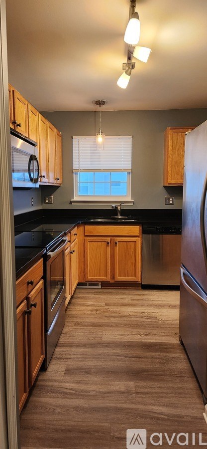 A kitchen with wooden cabinets and a black countertop.
