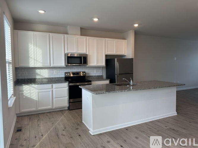 A kitchen with white cabinets and a granite countertop.