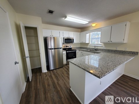 A kitchen with a granite countertop and stainless steel appliances.