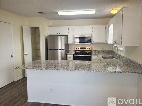 A kitchen with a granite countertop and stainless steel appliances.