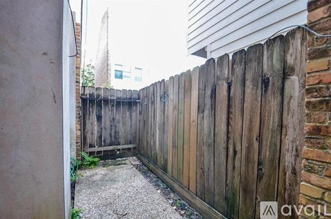 A wooden fence runs along the side of a building.
