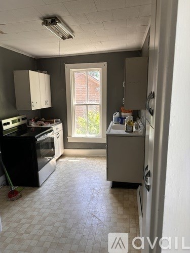 A kitchen with black appliances and white cabinets.