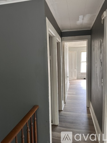 A long hallway with a wooden railing on the left.