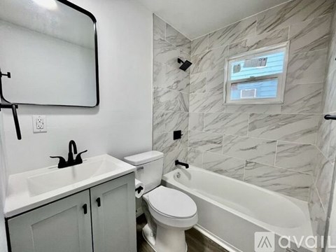 A white toilet sits next to a white sink in a bathroom.