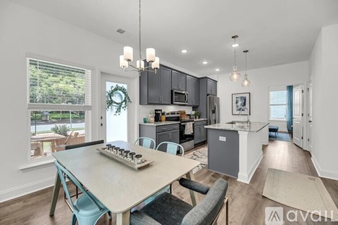 A kitchen with a table and chairs in front of it.