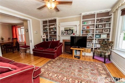 A living room with a red couch and a rug.