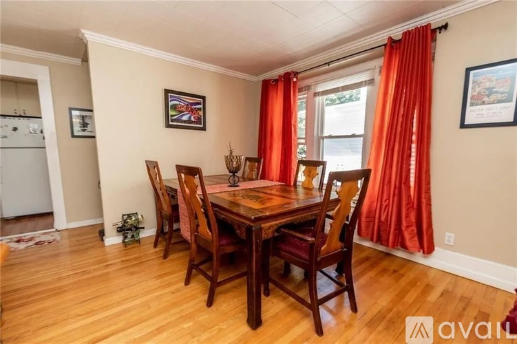 A dining room with a wooden table and chairs.