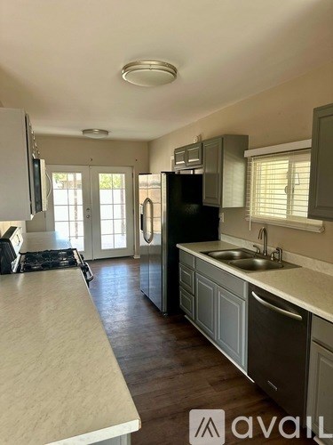 A kitchen with a black fridge and a white counter.