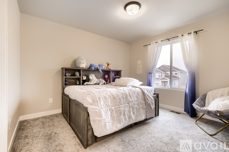 A bedroom with a large bed and a chair.