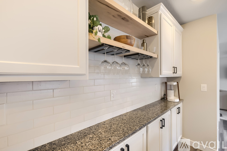 A kitchen with white cabinets and a granite countertop.