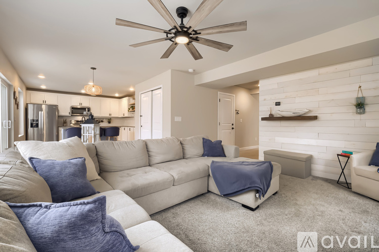 A living room with a white couch and a ceiling fan.