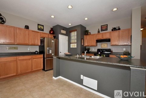 A kitchen with wooden cabinets and a black countertop.