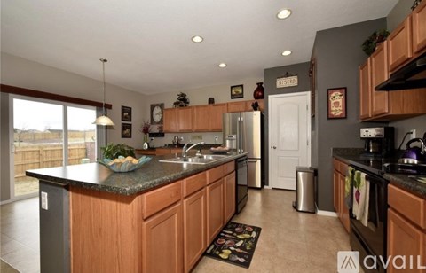 A kitchen with wooden cabinets and a granite countertop.
