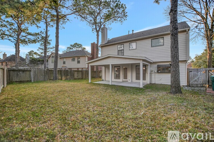 A house with a fence and trees in the yard.