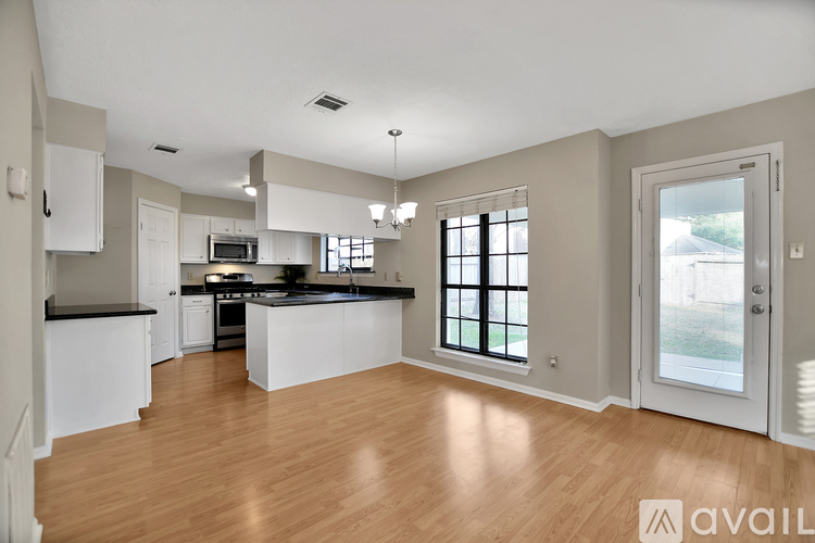 A kitchen with white cabinets and a black countertop.