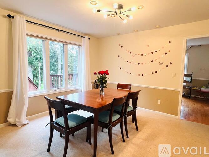 A dining room with a wooden table and chairs.