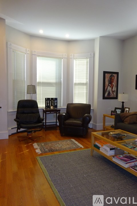 A living room with a black chair and a brown chair.
