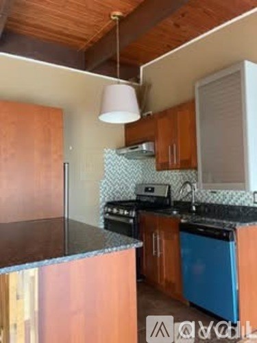 A kitchen with wooden cabinets and a blue fridge.