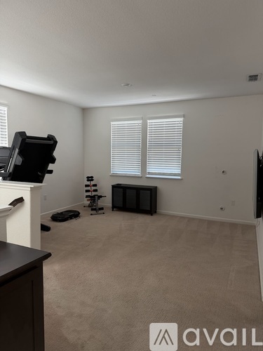 A living room with a television, a fireplace, and a pair of dumbbells.