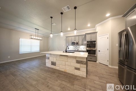 A kitchen with a stone counter and stainless steel appliances.