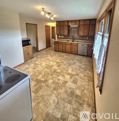 A kitchen with a tiled floor and wooden cabinets.