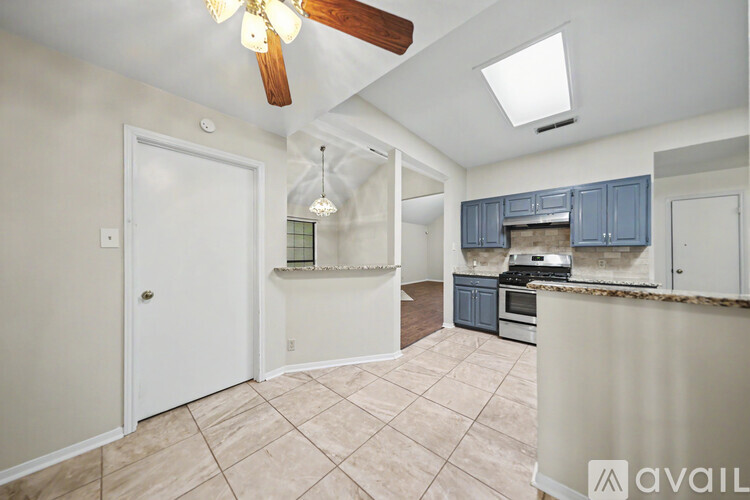 A kitchen with a white door and a ceiling fan.