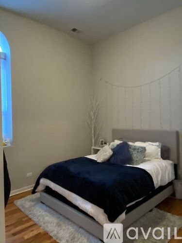 A bedroom with a bed, pillows, and a decorative wall hanging.