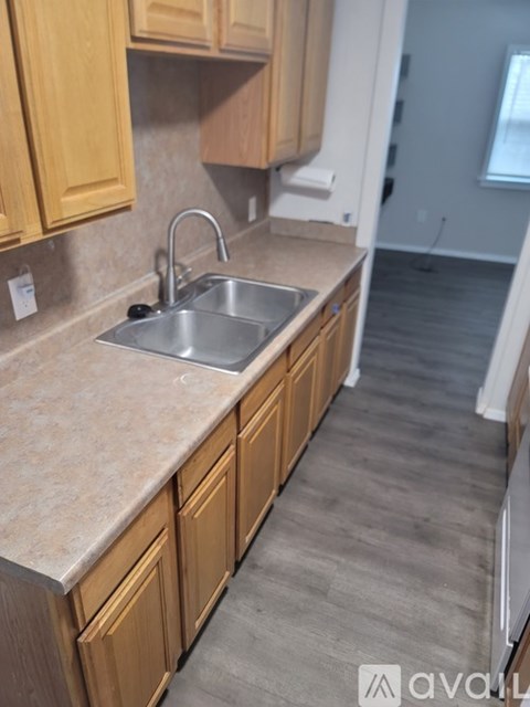 A kitchen with wooden cabinets and a stainless steel sink.