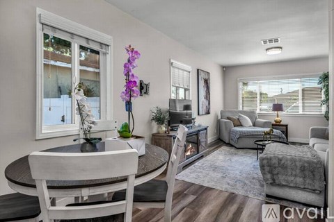 A living room with a dining table and chairs.