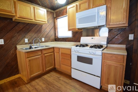 A kitchen with wooden cabinets and a white stove.